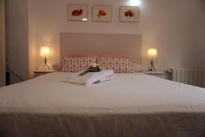 1 dormitorio con 1 cama blanca grande y 2 lámparas en Casa Marcur Santa Cruz, en Sevilla