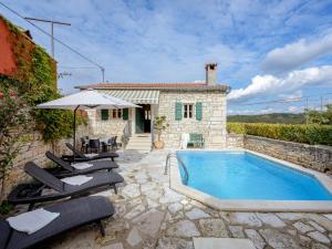 a villa with a swimming pool in front of a house at Casa Antignana in Tinjan