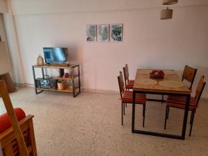 a dining room with a table and chairs and a tv at Departamento reciclado a nuevo a 3 cuadras del mar in Mar del Plata