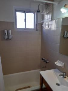 a bathroom with a tub and a sink and a window at Departamento reciclado a nuevo a 3 cuadras del mar in Mar del Plata