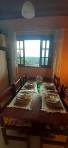 a dining room table with a view of a window at Casa Bela Vista in Campos do Jordão