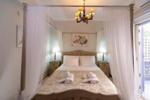 a bedroom with a bed with two pairs of shoes on it at Nautilus Luxury Suites in Galaxidi