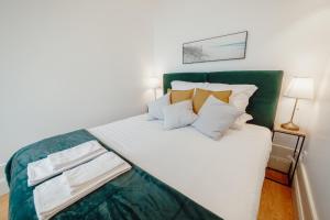 - une chambre avec un lit doté de draps et d'oreillers blancs dans l'établissement Downtown Premium Apartment by Vacationy, à Porto