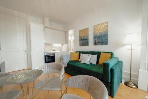 - un salon avec un canapé vert et des chaises dans l'établissement Downtown Premium Apartment by Vacationy, à Porto
