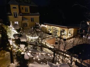 a house with lights in the snow at night at Ubytování v soukromí - Apartmán MERAN in Svoboda nad Úpou