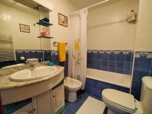 een badkamer met een wastafel, een toilet en een bad bij Apartamento de 2 hab. con todo lo necesario. in Gijón