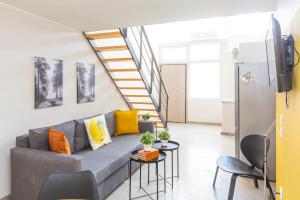 a living room with a couch and a staircase at Psirri Lofts in Athens