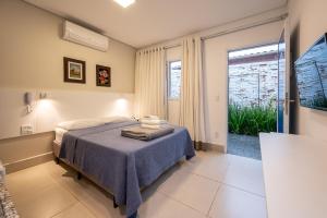 a bedroom with a bed and a large window at K2 Residence in Campinas