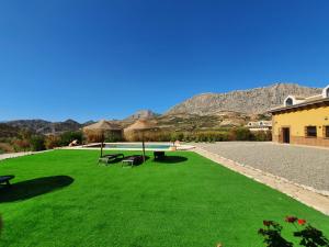 a green lawn with a picnic table and chairs on it at Casa Charo in Valle de Abdalagís