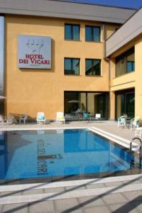 a hotel with a swimming pool in front of a building at Hotel Dei Vicari in Scarperia