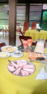 una mesa amarilla con platos de comida. en Golden waters Lodges, en Iquitos