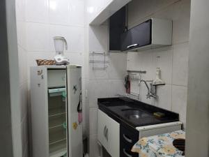 una pequeña cocina con fregadero y nevera. en Studio em Copacabana, 100m do mar, en Río de Janeiro