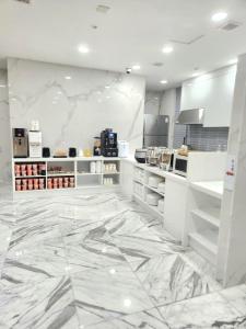 cocina grande con suelo de mármol y armarios blancos en Renaissance Hotel Pohang, en Pohang