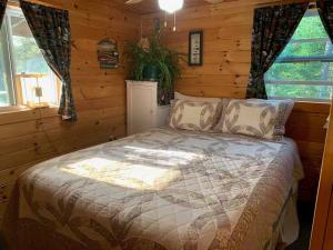 ein Schlafzimmer mit einem Bett in einem Blockhaus in der Unterkunft Middle Pond Cabin- Direct ATV & Snowmobile Access in Pittsburg