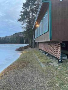 a house on the shore of a body of water at Middle Pond Cabin- Direct ATV & Snowmobile Access in Pittsburg