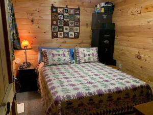1 dormitorio con 1 cama con pared de madera en Middle Pond Cabin- Direct ATV & Snowmobile Access, en Pittsburg