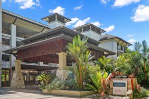 un grande edificio con palme di fronte di 303 Sea Temple Renovated Apartment a Palm Cove