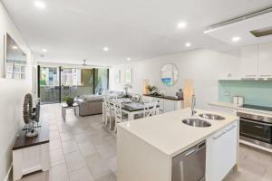 an open kitchen and living room with a couch at 303 Sea Temple Renovated Apartment in Palm Cove