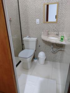 a bathroom with a toilet and a sink at Alvorada Guest House in Caxambu