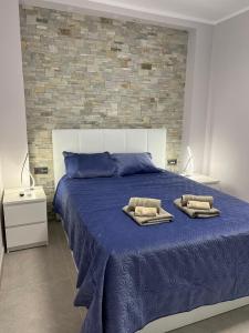 1 dormitorio con 1 cama azul y 2 toallas en Luxury Apartment Orlando, en Adeje