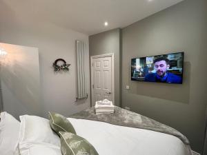 a bedroom with a bed with a tv on the wall at Winckley Square Residences in Preston