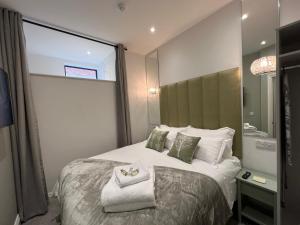 um quarto de hotel com uma cama grande e um espelho em Winckley Square Residences em Preston