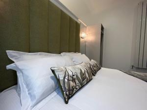 uma cama com almofadas brancas e uma cabeceira verde em Winckley Square Residences em Preston