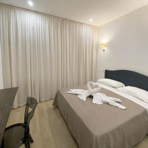 a hotel room with a bed with white towels on it at GUALTIERI B&b - LUXURY ROOMS in San Giorgio a Cremano