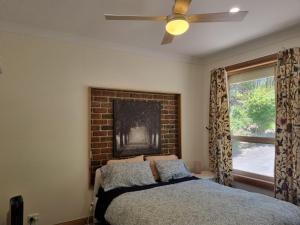 a bedroom with a bed and a brick wall at Sunset Hues -Enjoy Peace & Nature in Norton Summit