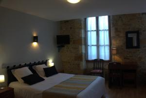 Un dormitorio con una cama grande y una ventana en Hôtellerie de l'Abbaye Saint Amand, en Saint-Amand-de-Coly