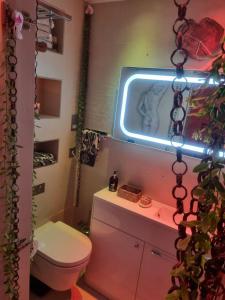 a bathroom with a toilet and a neon sign at London Park Haven in London