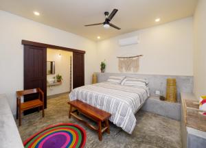 a bedroom with a bed and a table and a chair at Gallo Azul, Downtown Loft Style Apartment in Todos Santos