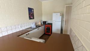 a small kitchen with a refrigerator and a stove at The Summit 10 in Jindabyne