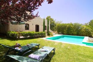 a backyard with a pool and a table and chairs at Villa Olympia - Villa Erato in Prinés