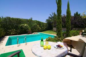 a table with fruit on it next to a swimming pool at Villa Olympia - Villa Erato in Prinés