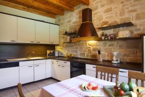 a kitchen with white cabinets and a table with food on it at Villa Olympia - Villa Erato in Prinés