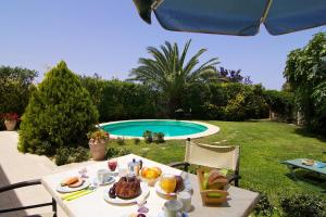 a table with food on it next to a pool at Villa Olympia - Villa Erato in Prinés