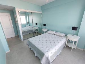 a blue bedroom with a bed and a mirror at Departamento Nuevo 2 amb con cochera Solo parejas o familias in Mar del Plata