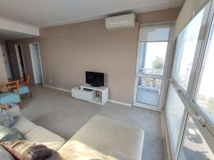 a living room with a couch and a tv at Departamento Nuevo 2 amb con cochera Solo parejas o familias in Mar del Plata