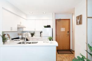 a white kitchen with a sink and a refrigerator at Slopeside Whistler Creek in Whistler