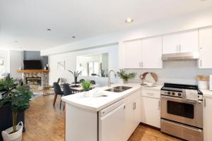 uma cozinha com armários brancos e uma sala de estar em Slopeside Whistler Creek em Whistler
