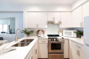 a kitchen with white cabinets and a sink at Slopeside Whistler Creek in Whistler