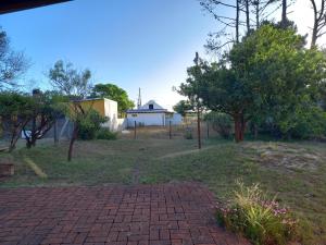 a brick driveway in a yard with trees and a house at Maneki in La Paloma