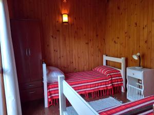 a small bedroom with a bed and a night stand at Maneki in La Paloma