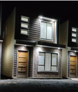 dom z dwoma drzwiami i oknami w nocy w obiekcie ENTRE CISNES 1, 2 y 3 Dorm w mieście Valdivia