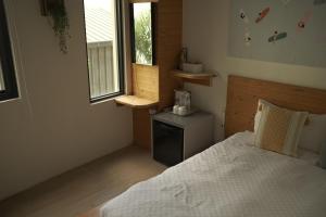 ein kleines Schlafzimmer mit einem Bett und einem Fenster in der Unterkunft Summer Delight B&B in Nanwan