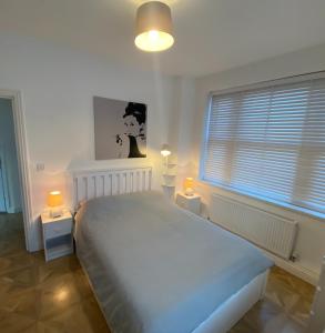 a bedroom with a large bed with two lights on it at Spacious 1 bedroom flat in London in London