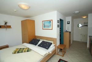 a bedroom with a bed and a cabinet in it at App Seeblick in ruhiger Lage in Seedorf in Seedorf