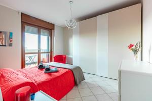 um quarto com uma cama vermelha e uma cadeira vermelha em La Casa Di Claudio - by Host4U em Melegnano