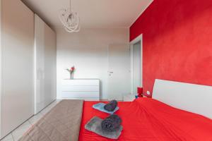 um quarto vermelho com uma cama com uma parede vermelha em La Casa Di Claudio - by Host4U em Melegnano